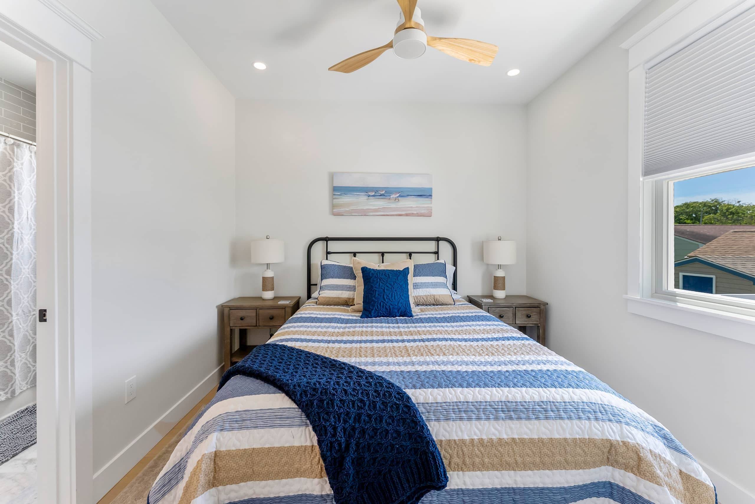 Bedroom at The Delford with a striped quilt and windows