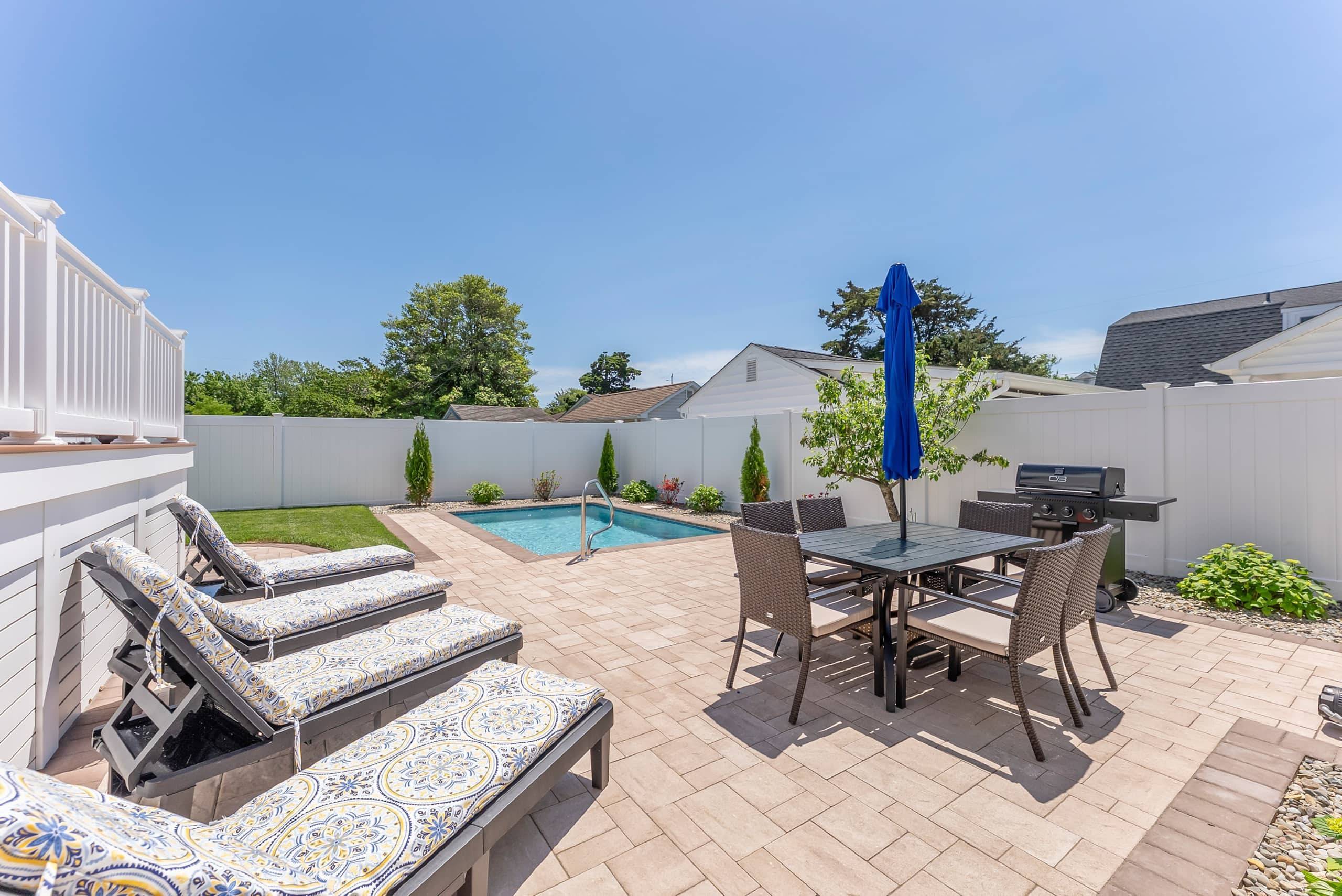 Heated pool and outdoor dining in the fenced yard at The Delford